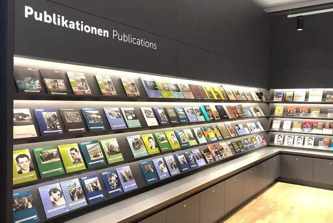 Bücherauslage mit vielen Publikationen in vier Regalreihen